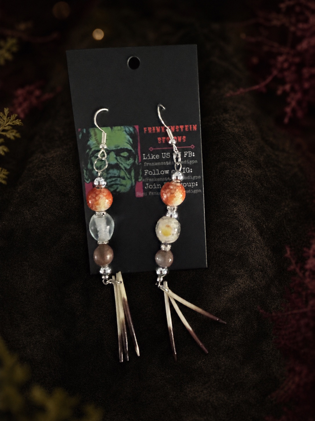 Pair of earth-tone beaded earrings with three reclaimed porcupine quills on each earring, displayed on a Frankenstein Designs card